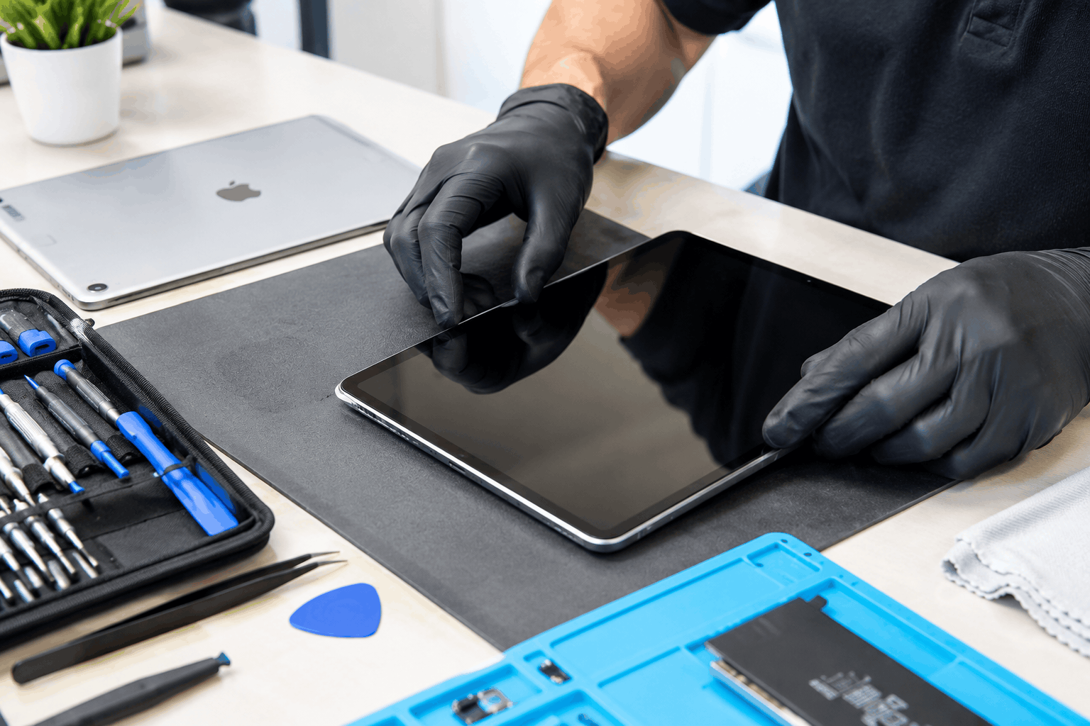 Tablet and iPad repair in Minneapolis with a technician carefully working on a tablet using precision repair tools.